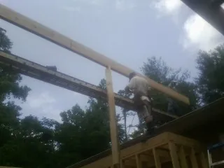 Carpenter setting a ridge beam over a new addition frame — Ice Dam Removal by Roofing Brothers in East Aurora