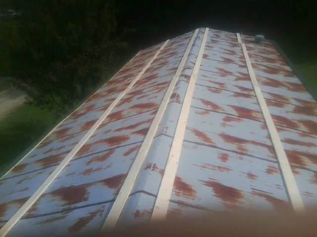 Rusted metal roof panels with new wood purlins before replacement — Storm Damage Roof Repair in East Aurora by Roofing Brothers